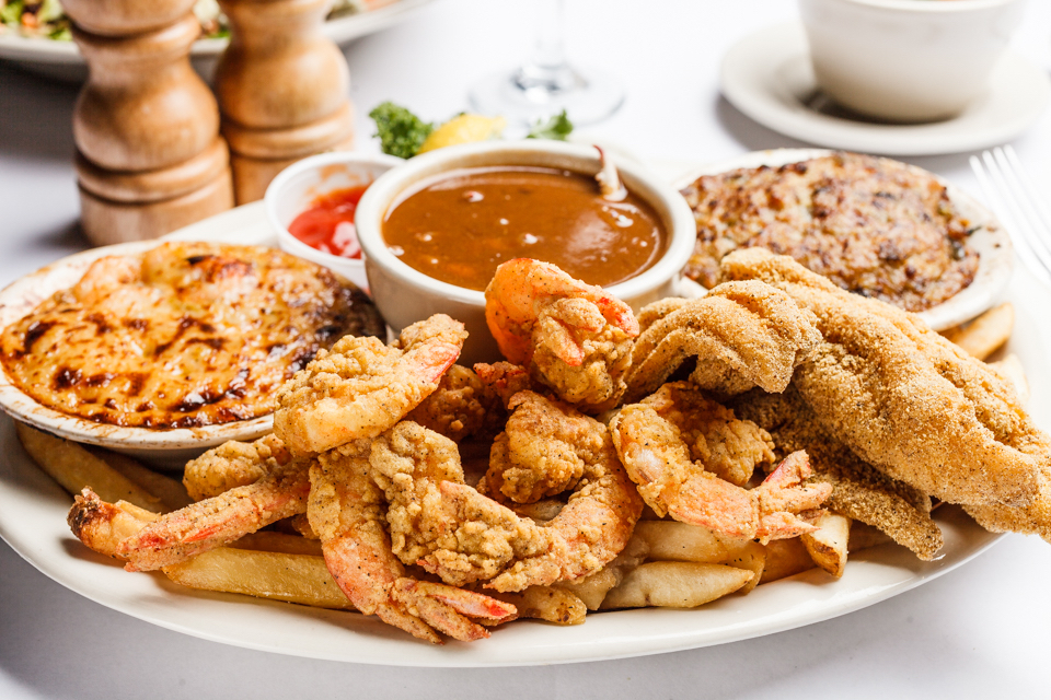 A large platter of fried seafood over french fries