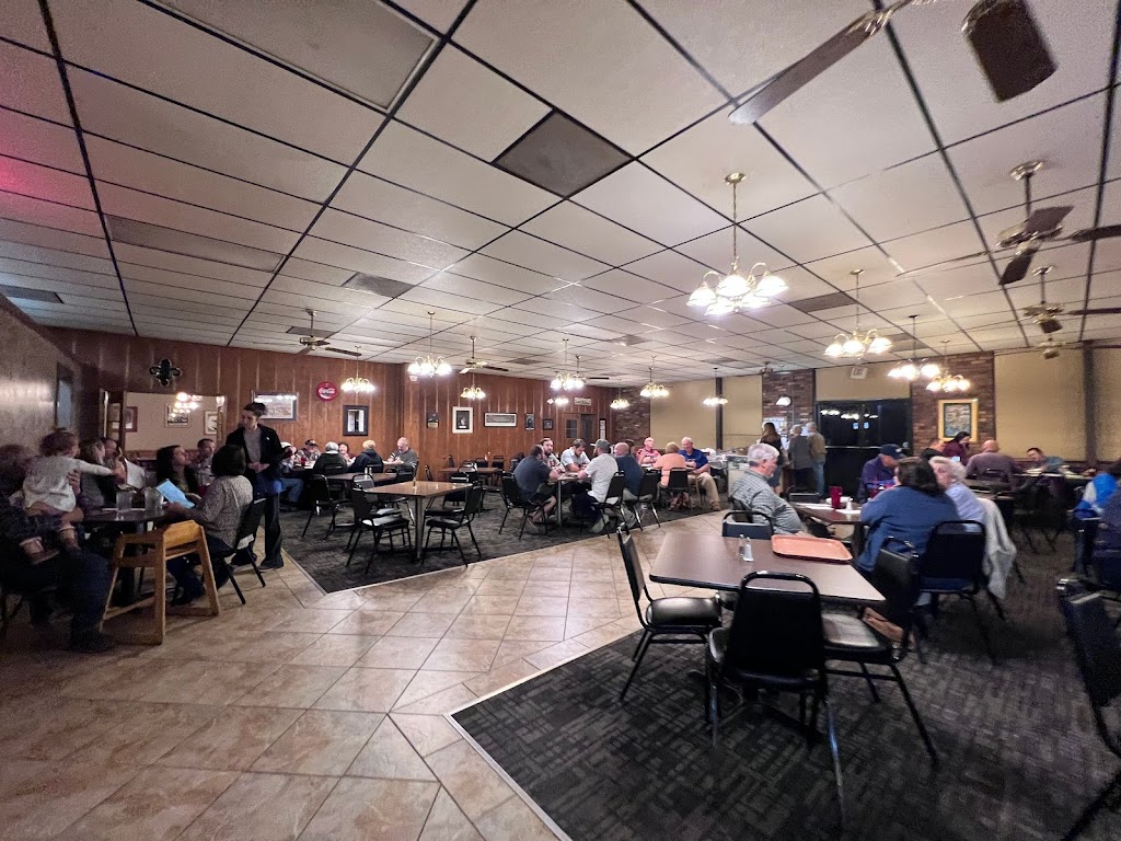 The dining room at Bourne's with guests seated at tables under ceiling fans and hanging lights